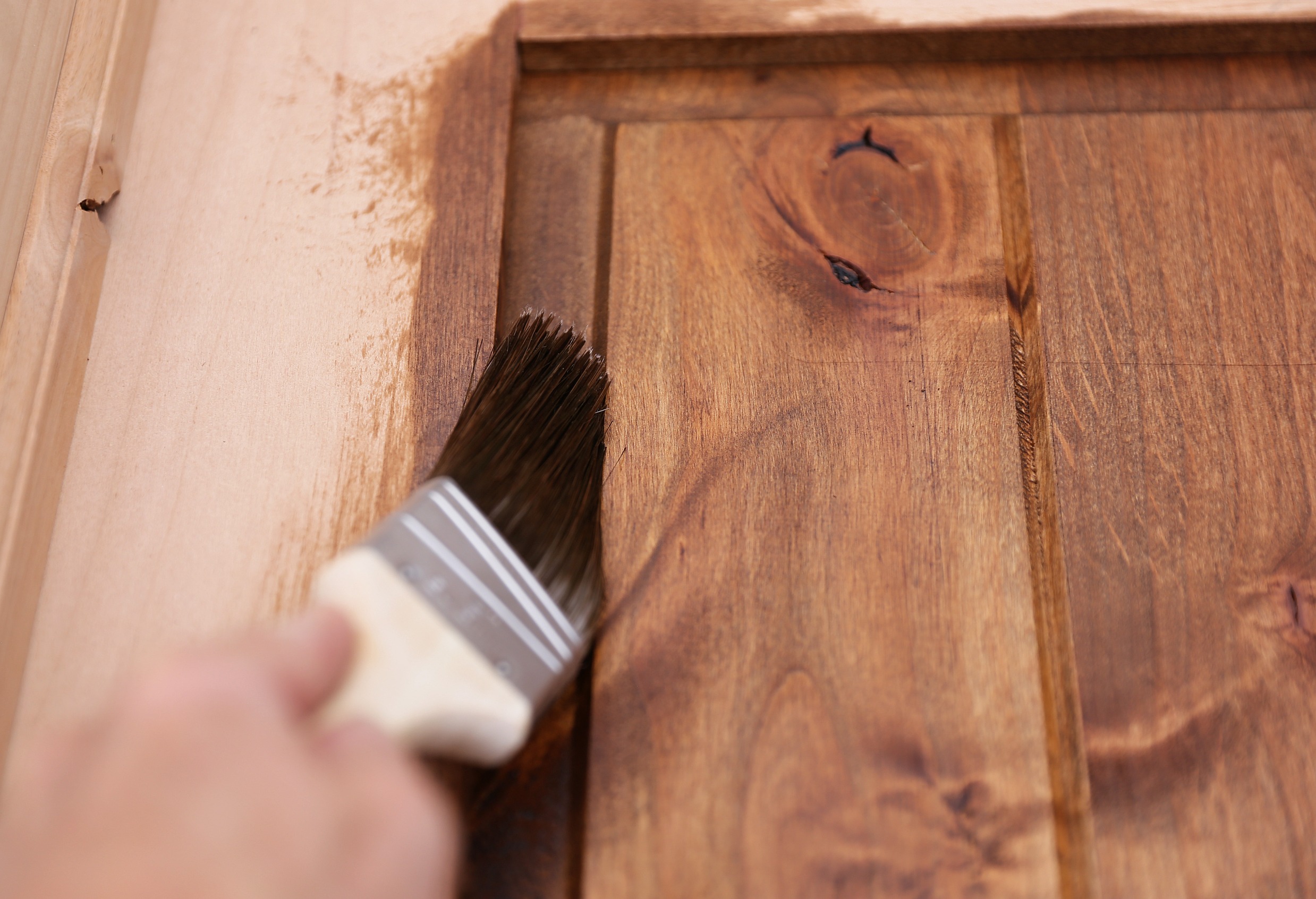 mano de pintor pasando brocha en madera